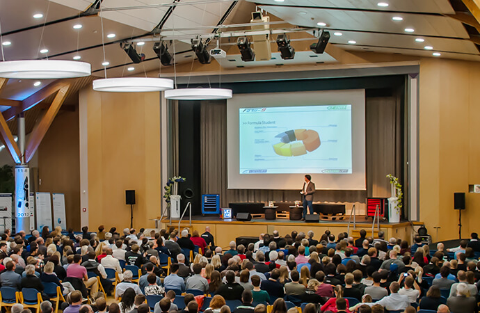 Großer Raum mit Leinwand, Bestuhlung und Publikum