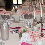 Gedeckter Tisch mit Kerzen und Blumenschmuck