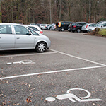 Parkplatz mit Fahrzeugen und Behindertenparkplätzen